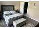 Cozy bedroom featuring a gray upholstered bed, bench, and an ensuite bathroom through the open door at 7838 Chesapeake E Dr, Indianapolis, IN 46236