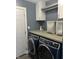 Well-organized laundry room with a washer and dryer, cabinets, and gray walls at 7838 Chesapeake E Dr, Indianapolis, IN 46236
