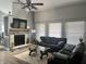 Cozy living room showcasing a fireplace, plush sofas, and a modern ceiling fan at 7838 Chesapeake E Dr, Indianapolis, IN 46236