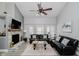 Spacious living room featuring a stone fireplace, ceiling fan, and ample natural light at 7838 Chesapeake E Dr, Indianapolis, IN 46236