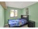 Cozy bedroom featuring a dark wood bed frame and bedside table, complemented by a window for natural light at 7915 Broadview Dr, Indianapolis, IN 46227