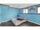 A bright blue bedroom with light from the windows and an air mattress on wood-look floors at 7915 Broadview Dr, Indianapolis, IN 46227