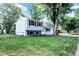 A charming two-story home shows off its backyard from the side with blue siding and a sprawling green lawn at 7915 Broadview Dr, Indianapolis, IN 46227