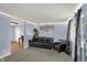Comfortable living room with a black leather sofa, grey carpet and natural light at 7915 Broadview Dr, Indianapolis, IN 46227