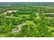 Wide aerial view showcasing a tranquil pond, surrounded by lush greenery and verdant trees at 8000 Mcwhorter Rd, Martinsville, IN 46151