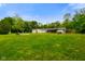 Lush backyard with a fire pit area, covered patio, outdoor seating, and well-manicured lawn at 8000 Mcwhorter Rd, Martinsville, IN 46151