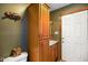 Functional bathroom with wood cabinets, a white door, and a sink vanity at 8000 Mcwhorter Rd, Martinsville, IN 46151