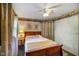 Charming bedroom featuring blue textured walls, a ceiling fan, and a wooden bed frame at 8000 Mcwhorter Rd, Martinsville, IN 46151