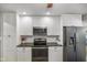Well-lit kitchen featuring white cabinets, stainless steel appliances and black countertops at 8000 Mcwhorter Rd, Martinsville, IN 46151