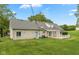 Stone house back exterior featuring well-maintained lawn, deck, and mature trees providing an inviting outdoor space at 8465 Hilltop Ln, Martinsville, IN 46151