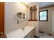 Traditional bathroom with a vanity, unique mirror, and decorative wallpaper adding vintage charm at 8465 Hilltop Ln, Martinsville, IN 46151