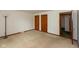 Spacious bedroom with tan carpet, two closets, and natural light from an open doorway at 8465 Hilltop Ln, Martinsville, IN 46151