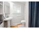 Clean and modern bathroom with pedestal sink, toilet, and blue shower curtain at 9104 W Lone Beech Dr, Muncie, IN 47304