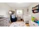 Cozy Bedroom with a crib, comfortable chair, plush rug, and colorful decor at 9104 W Lone Beech Dr, Muncie, IN 47304