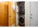Efficient laundry area featuring a stacked washer and dryer with nearby storage and doors at 9104 W Lone Beech Dr, Muncie, IN 47304