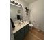 Cozy half-bathroom featuring tiled floors, decorative shelves, and a vanity with an oval sink at 9535 Longwell Dr, Indianapolis, IN 46240
