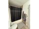 Bathroom with shower-tub combination, dark shower curtain, and gray bathmat at 9535 Longwell Dr, Indianapolis, IN 46240