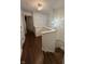 Light-filled hallway with hardwood floors, leading to the staircase with a chandelier at 9535 Longwell Dr, Indianapolis, IN 46240