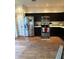 Bright kitchen with stainless steel appliances, dark cabinets, and hardwood flooring at 9535 Longwell Dr, Indianapolis, IN 46240