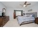 Bedroom features light-gray walls, a ceiling fan, and a cozy bed with a padded headboard at 9689 Wild Iris Dr, Noblesville, IN 46060