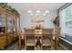 Elegant dining room with wooden table, six chairs, stylish lighting, and classic hutch at 9689 Wild Iris Dr, Noblesville, IN 46060
