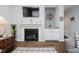 Cozy living room featuring a fireplace, built-in storage, and elegant decor accents with hardwood floors at 9689 Wild Iris Dr, Noblesville, IN 46060
