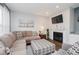 Relaxing living room with a fireplace, a plush sofa, and a patterned ottoman, perfect for gatherings at 9689 Wild Iris Dr, Noblesville, IN 46060