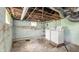 An unfinished basement shows the laundry area with a washer and dryer at 102 N Whitcomb Ave, Indianapolis, IN 46224