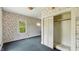 Bedroom featuring floral wallpaper, closet, and natural light from a window at 102 N Whitcomb Ave, Indianapolis, IN 46224