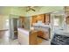 Cozy kitchen with wood cabinets and stainless steel refrigerator, ready for renovation at 102 N Whitcomb Ave, Indianapolis, IN 46224