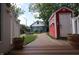 Charming backyard featuring a red shed, brick path, manicured lawn, and two story home at 1156 Spruce St, Indianapolis, IN 46203
