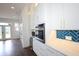 A bright, modern kitchen with white cabinets, herringbone backsplash, and stainless steel appliances at 1156 Spruce St, Indianapolis, IN 46203