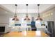 Spacious kitchen with a center island, stainless appliances, stylish lighting and herringbone backsplash at 1156 Spruce St, Indianapolis, IN 46203