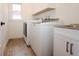 Bright laundry room with wooden floors, sink, and stainless steel washer and dryer at 1156 Spruce St, Indianapolis, IN 46203