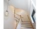 Bright staircase with decorative chandelier, white railing, wooden stairs and a window with views at 1156 Spruce St, Indianapolis, IN 46203