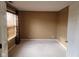 Vacant bedroom with neutral carpet, window with horizontal blinds and natural light, and brown walls at 11754 Hamble Dr, Indianapolis, IN 46235