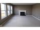 Cozy living room boasts carpet, a white fireplace, and large windows letting in natural light at 11754 Hamble Dr, Indianapolis, IN 46235