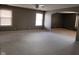 Spacious living room with neutral carpet, multiple windows, and open archway to another room at 11754 Hamble Dr, Indianapolis, IN 46235