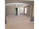 Bright living room with neutral carpet and an archway entrance and multiple windows with coverings at 11754 Hamble Dr, Indianapolis, IN 46235