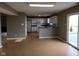 Open-concept living area with wood flooring, a breakfast bar, white cabinets, and a sliding glass door at 11754 Hamble Dr, Indianapolis, IN 46235