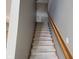 Carpeted stairway with gray walls and a wooden handrail leading to the upper level of the home at 11754 Hamble Dr, Indianapolis, IN 46235