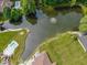 Expansive aerial view of a property featuring a large pond with a fountain and swimming pools at 120 Wagon Trail, Mooresville, IN 46158