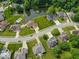 A neighborhood aerial view with beautiful homes surrounding a pond and pool, nestled among mature trees at 120 Wagon Trail, Mooresville, IN 46158