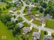 Neighborhood aerial view highlighting well-manicured homes surrounding a pond and pool, framed by lush greenery and quiet streets at 120 Wagon Trail, Mooresville, IN 46158