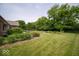 Lush backyard featuring green lawn, decorative plants and shrubs and mature trees at 120 Wagon Trail, Mooresville, IN 46158
