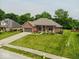 Beautiful brick home featuring a well-groomed lawn, mature trees, and colorful flowerbeds, enhancing its inviting appeal at 120 Wagon Trail, Mooresville, IN 46158