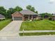 Charming brick home with a manicured lawn, beautiful flowerbeds, and a cozy front porch, offering curb appeal and a welcoming entrance at 120 Wagon Trail, Mooresville, IN 46158