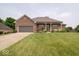 Charming brick home featuring an attached two-car garage, front porch, and well-manicured lawn at 120 Wagon Trail, Mooresville, IN 46158