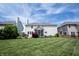 Exterior backyard of home with screened in porch, patio with table, and green lawn at 12093 Ashland Dr, Fishers, IN 46037