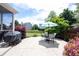 Landscaped backyard patio area featuring a dining set with umbrella, and a covered grill at 12093 Ashland Dr, Fishers, IN 46037